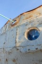 Frozen porthole on the old white ships wall .