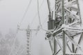 Frozen power line pylons. Hoarfrost on high voltage cables and pylons. Winter in the mountains