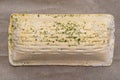 Frozen puff pastry with salmon lying on baking paper, isolated on a brown background top view.