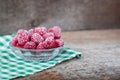 Frozen raspberries in a glass dessert bowl on the white and green checked napkin. Royalty Free Stock Photo