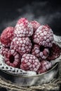 Frozen raspberries pairs black background of winter berries