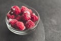 Frozen raspberries in plate on black table. Winter vitamin dessert Royalty Free Stock Photo