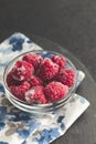 Frozen raspberries in plate on black table. Winter vitamin dessert Royalty Free Stock Photo