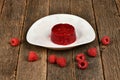 Frozen raspberry smoothies and fresh raspberries on white plate on wooden background. Side view Royalty Free Stock Photo