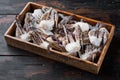 Frozen raw  blue swimming crab parts, in wooden box, on dark wooden background Royalty Free Stock Photo