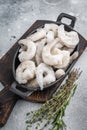 Frozen raw shrimp prawns in a rustic skillet with fresh thyme on a gray stone background. Flat lay with copy space. Royalty Free Stock Photo