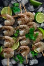 Frozen raw shrimp vannamey, on wooden skewers, ice cubes and lime slices, top view, no people, Royalty Free Stock Photo