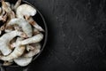 Frozen raw uncooked tiger prawns, shrimps, in cast iron frying pan, on black stone background, top view flat lay, with copy space Royalty Free Stock Photo