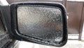 Frozen rearview mirror of the car with ice.Consequences of rain and frost. Front view Royalty Free Stock Photo