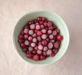 Frozen cranberry in green bowl close up. White linen cloth background view. Healthy eating concept Royalty Free Stock Photo