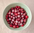 Frozen cranberry in green bowl close up. White linen cloth background view. Healthy eating concept Royalty Free Stock Photo