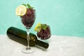 frozen red wine in two glass glasses decorated with a slice of lemon and lemon leaves and an empty glass bottle Royalty Free Stock Photo