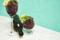 frozen red wine in two glass glasses decorated with a slice of lemon and lemon leaves and an empty glass bottle Royalty Free Stock Photo