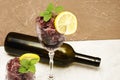 Frozen red wine in two glass glasses decorated with a slice of lemon and lemon leaves and an empty glass bottle Royalty Free Stock Photo