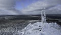 Frozen repeater antenna on the top of a hill in winter. Clip. Aerial view of winter valley panorama and blue cloudy sky. Royalty Free Stock Photo