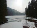 A frozen river between mountains and trees Under the mist and mystical sky Royalty Free Stock Photo