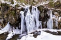 Frozen river waterfall formed during cold winter in the mountains of Romania