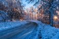 Frozen road in a snowy forest at sunset Royalty Free Stock Photo