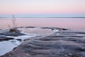 Frozen rock lake shore at dusk