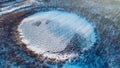 Frozen round winter lake ice aerial view. Beautiful clear blue ice stock photo from bird`s eye view. Selective focus, blurred