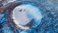 Frozen round winter lake ice aerial view. Beautiful clear blue ice stock photo from bird`s eye view. Selective focus, blurred