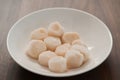 Frozen scallops in white bowl on walnut table for defrosting Royalty Free Stock Photo