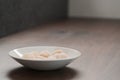 Frozen scallops in white bowl on walnut table for defrosting Royalty Free Stock Photo