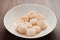 frozen scallops in white bowl on walnut table for defrosting Royalty Free Stock Photo