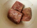 Frozen seasoned beef meat squares in white plastic container Royalty Free Stock Photo