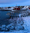 Frozen shore with a wooden pier of the Vadso village