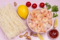 Frozen shrimp and ice in pink bowl. Rice noodles, lemon, mint garlic, tomato sauce Royalty Free Stock Photo
