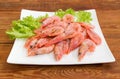 Frozen shrimps with lettuce on dish closeup on old table