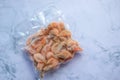 Frozen shrimps in vacuum transparent plastic packaging bag on white table background. Top view, copy space Royalty Free Stock Photo