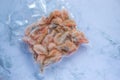 Frozen shrimps in vacuum transparent plastic packaging bag on white table background. Top view, copy space Royalty Free Stock Photo