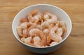 Frozen shrimps in a white bowl, isolated on wooden background Royalty Free Stock Photo