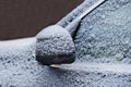 Frozen snow rearview mirror  of black car with ice and frost.Side view by close up.Selective focus.Concept of dangerous winter Royalty Free Stock Photo