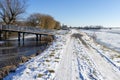 Frozen and snowy Dutch landscape with clear blue sky. frozen water in canal