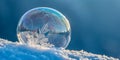 Frozen soap bubble with ice crystals, reflecting winter landscape on snow surface under blue sky Royalty Free Stock Photo