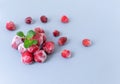 Frozen strawberries with sprigs of lemon balm on a gray background.