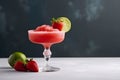 Frozen strawberry margarita garnished with a salt rim and a lime slice on grey, copy space. Margarita with crushed ice. Frozen Royalty Free Stock Photo