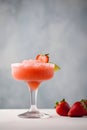 Frozen strawberry margarita garnished with a salt rim and a lime slice on grey, vertical. Margarita with crushed ice. Frozen red Royalty Free Stock Photo