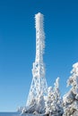 Frozen television or cellular tower in heavy snow near ski center. Telecommunication towers with dish and mobile antenna against Royalty Free Stock Photo