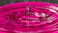 Frozen in time a pink water splash column attached to a sphere on top - stock photo Royalty Free Stock Photo