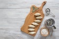 Frozen uncooked dumplings on a wooden board. Traditional homemade food. Top view