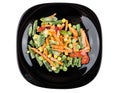 Frozen vegetable mix in black plate isolated on white Royalty Free Stock Photo