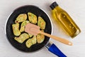 Frozen vegetable nuggets in frying pan, spatula, bottle of oil Royalty Free Stock Photo