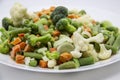 Frozen vegetables: cauliflower, green peas, leeks, broccoli, carrots, green beans on a white plate Royalty Free Stock Photo