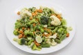 Frozen vegetables: cauliflower, green peas, leeks, broccoli, carrots, green beans on a white plate