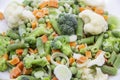 Frozen vegetables: cauliflower, green peas, leeks, broccoli, carrots, green beans on a white plate