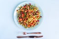 Frozen vegetables in a light plate and cutlery on a light background. Royalty Free Stock Photo